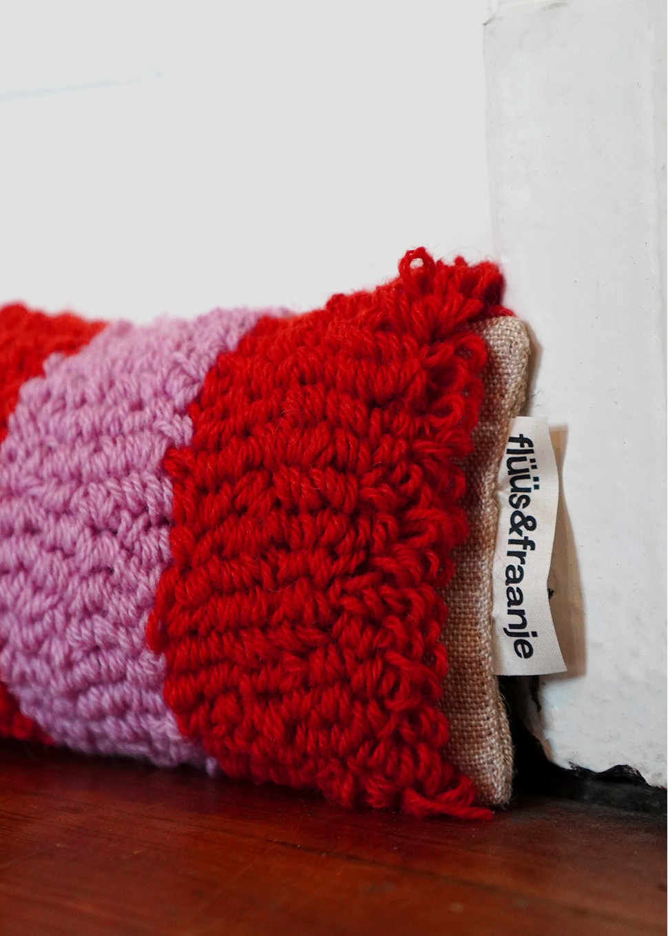 gestreifter Zugluftstopper Windfried vor Tür